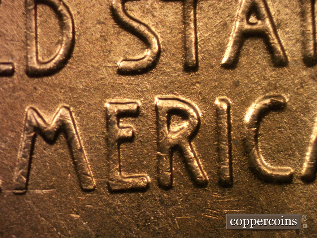 Die-stage B marker on 1958D•1MM•049 showing Die scratches show in MER of AMERICA.