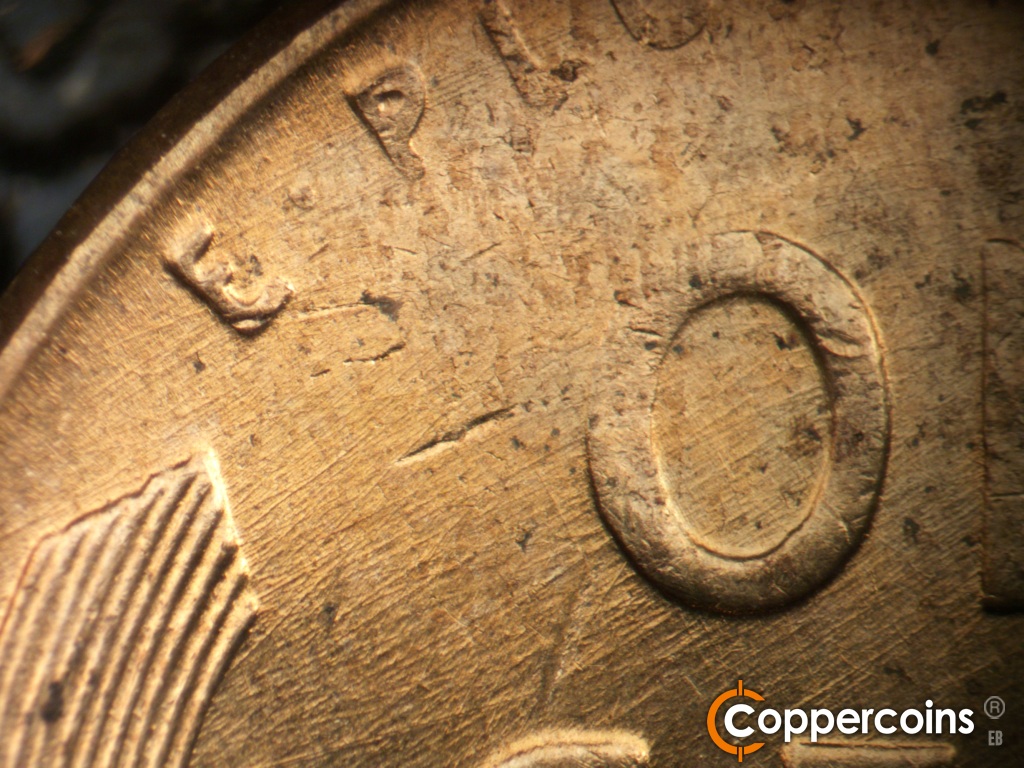 Die-stage C marker on 1958D•1MM•112 showing NE die scratches cover left upper reverse.
