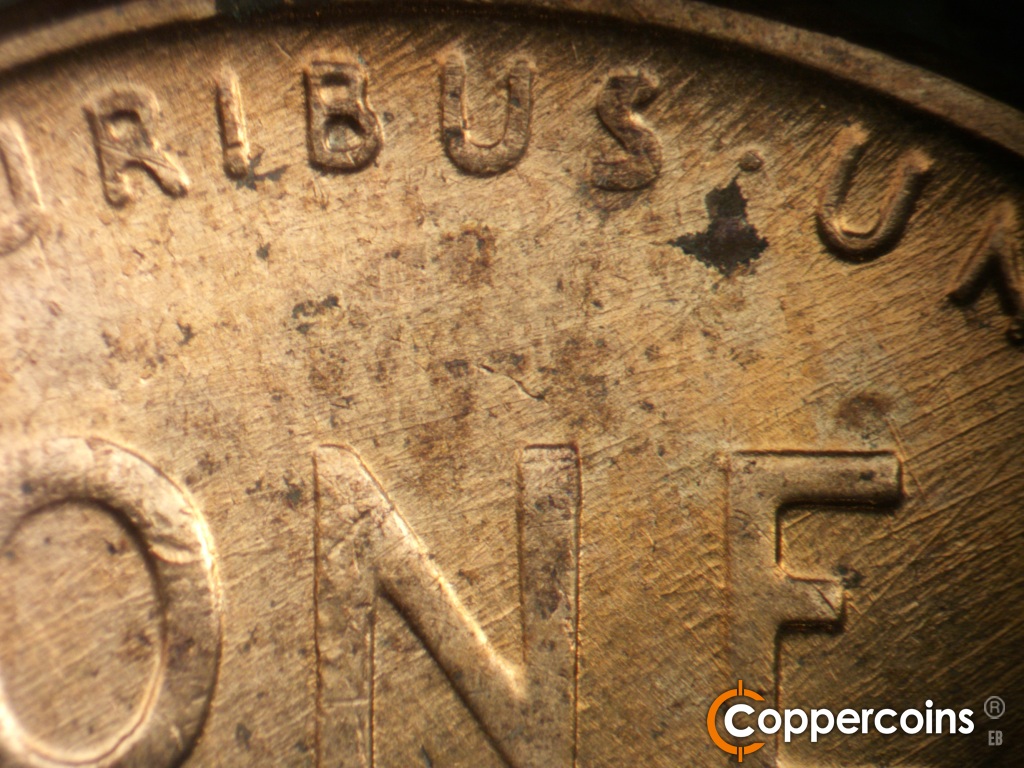 Die-stage C marker on 1958D•1MM•112 showing Generally ENE die scratches cover top center of reverse.