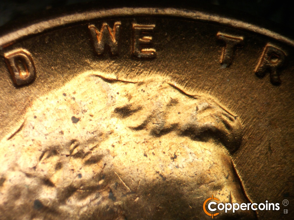 Die-stage B marker on 1958D•1MM•116 showing NE die scratch connects hair to bottom of W in WE.