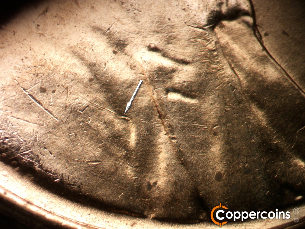 Die-stage B marker on 1959D•1MM•129 showing Die gouge on shoulder fold.