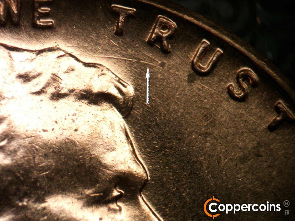 Die-stage B marker on 1959D•1MM•129 showing Concentric die gouge from front tip of hair running under TRUST.