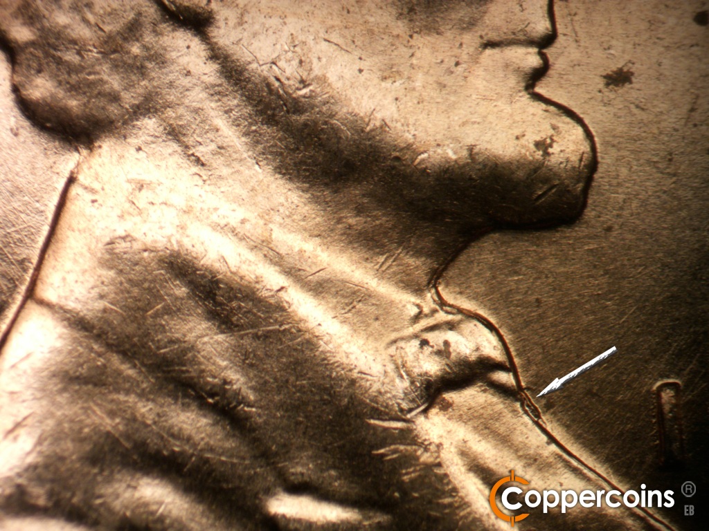 Die-stage B marker on 1959D•1MM•129 showing Die gouge under bowtie.