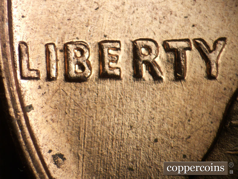 Die-stage B marker on 1960D•1DO•001 showing N-S die scratches under LIBERTY.
