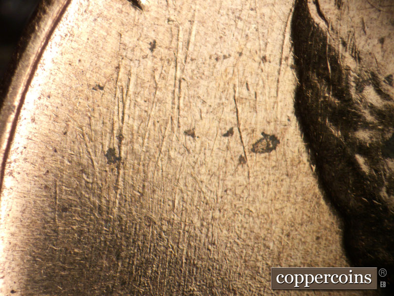 Die-stage B marker on 1960D•1DO•001 showing N-S die scratches behind head.