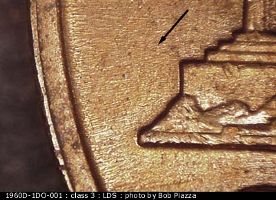 Die-stage C marker on 1960D•1DO•001 showing WNW die scratch from upper left base.