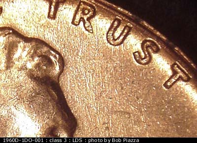 Die-stage C marker on 1960D•1DO•001 showing N/S die scratches in front of forehead.