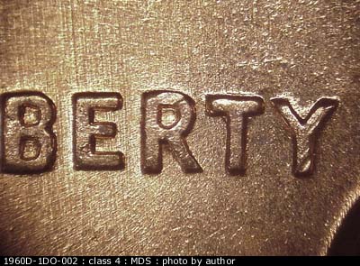 Die-stage B marker on 1960D•1DO•002 showing Doubling to the north shows on RTY of LIBERTY and the date. Light N/S die scratches.