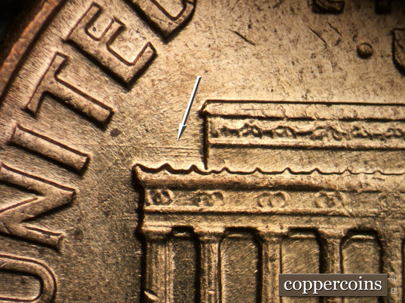 Die-stage B marker on 1960D•1DO•007 showing E/W die scratch above left cornice.