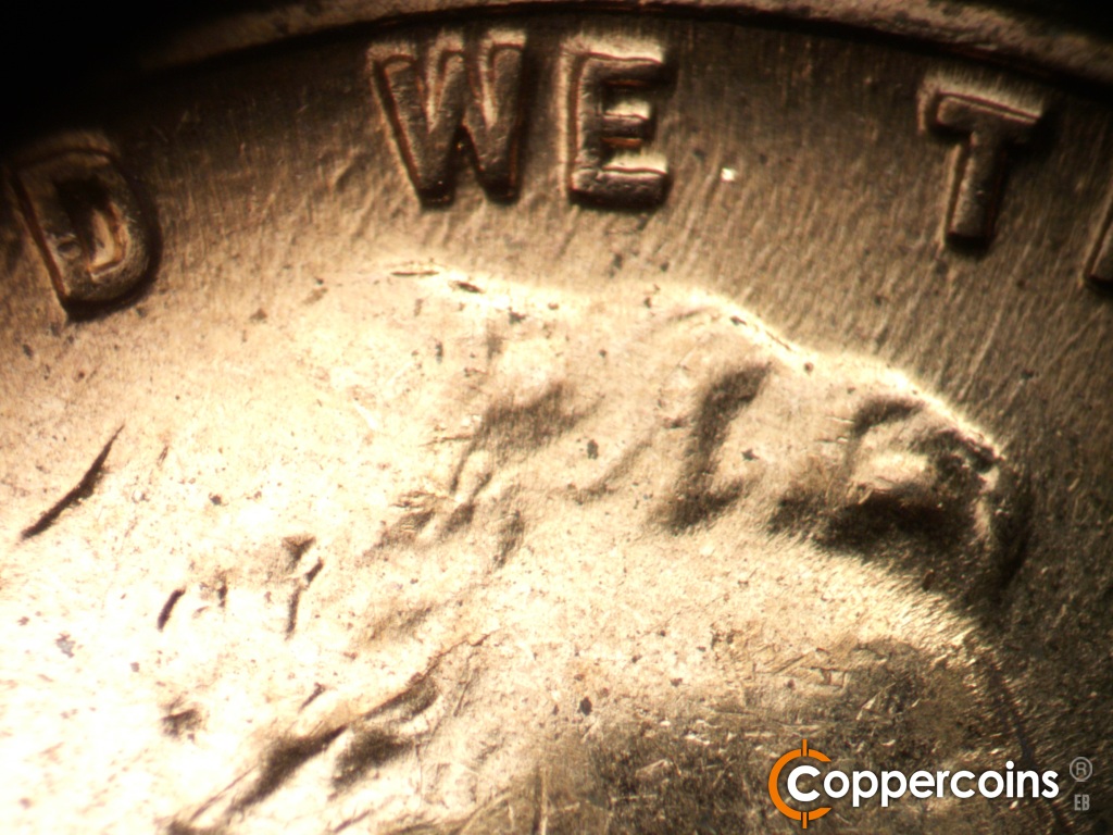 Die-stage C marker on 1960D•1DO•007 showing Worn NE die scratches from hair into WE.