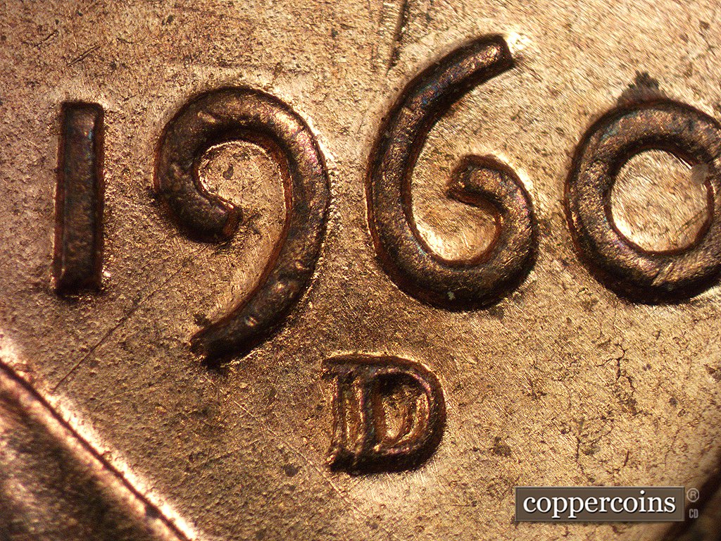 Die-stage A marker on 1960D•1MM•001 showing Die scratch from the inside of the 9 southwest to the vest. Another die scratch runs SE from the lower tip of the 9.