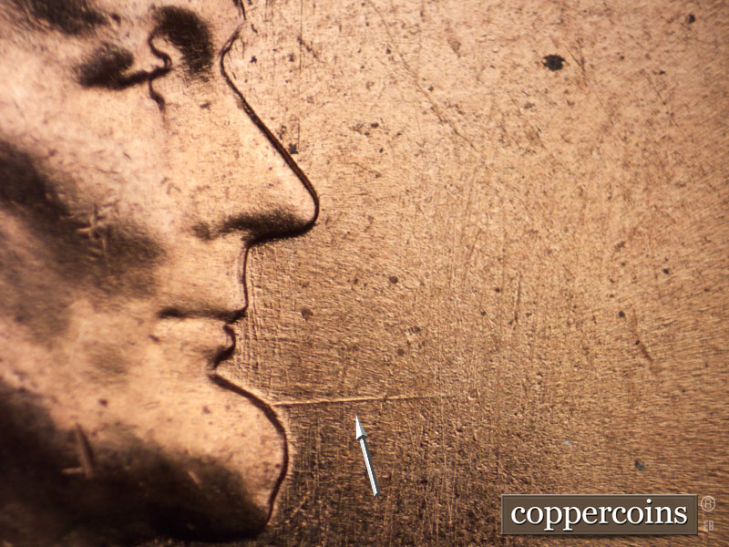 Die-stage C marker on 1960D•1MM•001 showing Heavy die scratch heads east from chin.
