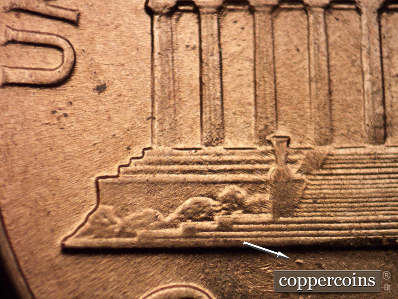 Die-stage B marker on 1960D•1MM•002 showing The entire reverse is design-soft because of die wear. Another look at the die dot below the left base.