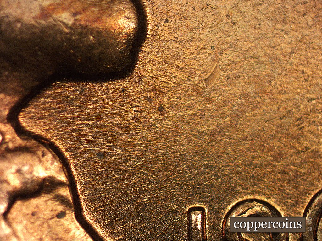 Die-stage C marker on 1960D•1MM•002 showing Die gouge beneath and slightly ti the right of the bottom of the chin.