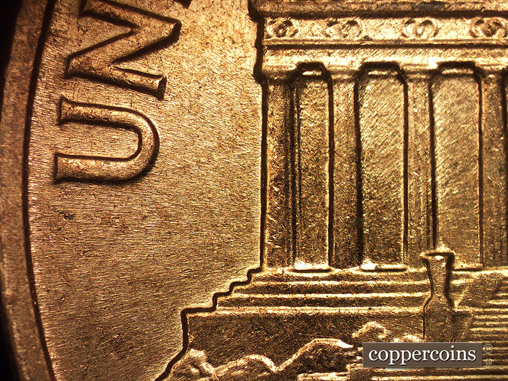 Die-stage C marker on 1960D•1MM•003 showing Die scratch connects U of UNITED with the first column in the building.