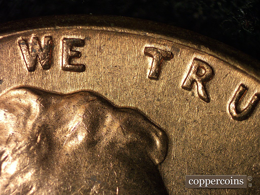 Die-stage A marker on 1960D•1MM•004 showing An assortment of die scratches show in the area of WE and TR of TRUST.