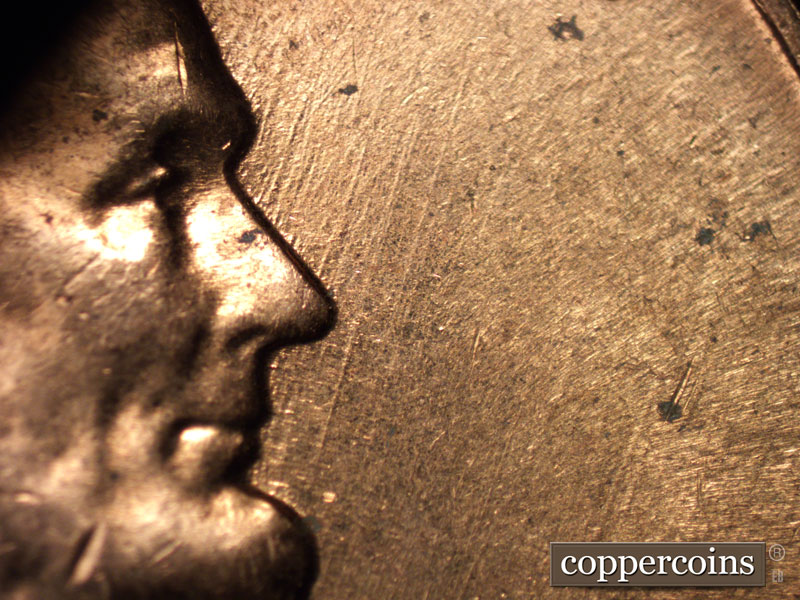 Die-stage C marker on 1960D•1MM•005 showing NE die scratches in front of face.