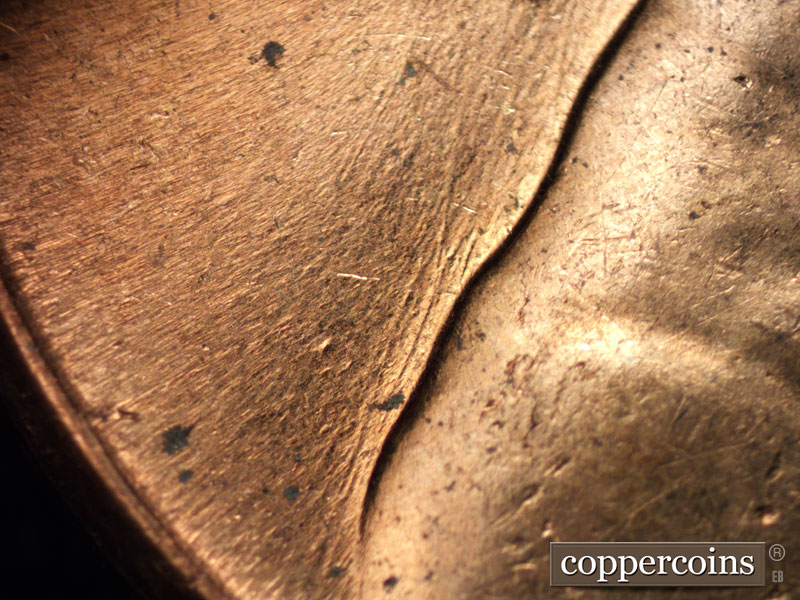 Die-stage C marker on 1960D•1MM•005 showing NE/SW die scrathces behind shoulder.