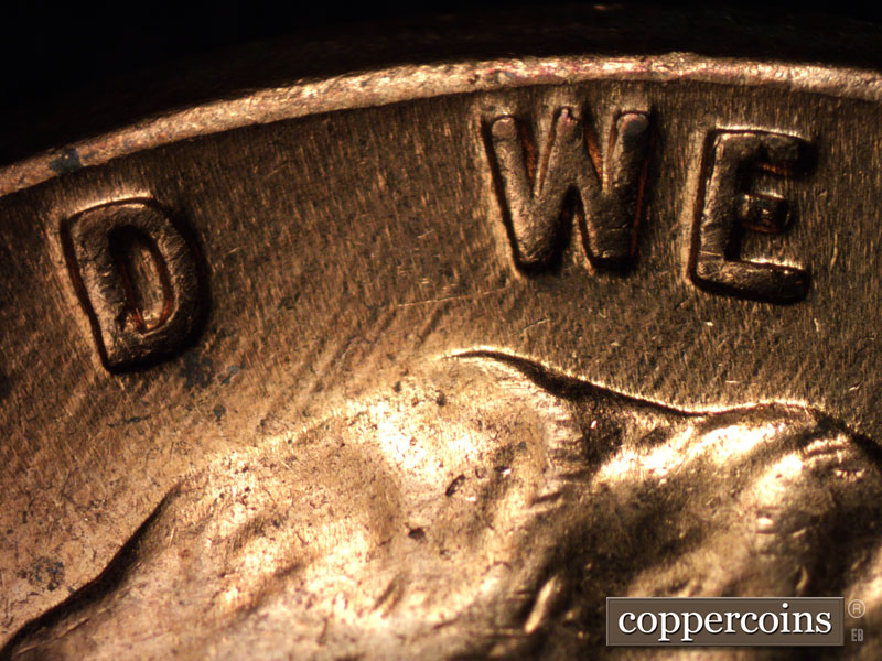 Die-stage C marker on 1960D•1MM•005 showing NE die scratches from top of head through WE.