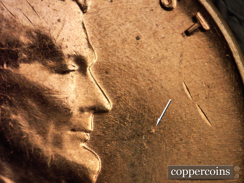 Die-stage B marker on 1960D•1MM•006 showing Die dot in fron of mouth.