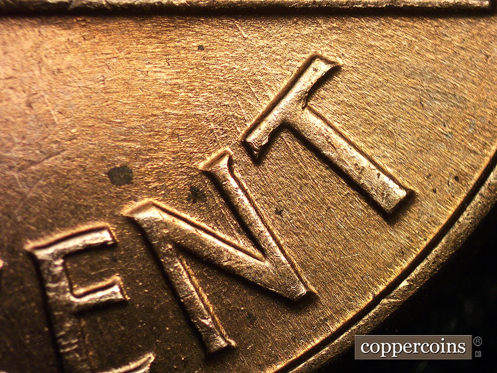 Die-stage C marker on 1960D•1MM•006 showing Die scratches in the lower half of the field are aged.