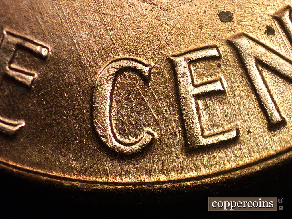 Die-stage C marker on 1960D•1MM•006 showing Die scratches show in the entire lower half of the design.