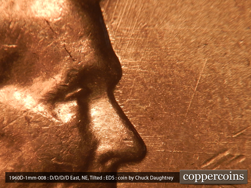 Die-stage A marker on 1960D•1MM•008 showing Multidirectional die scratches in front of forehead.
