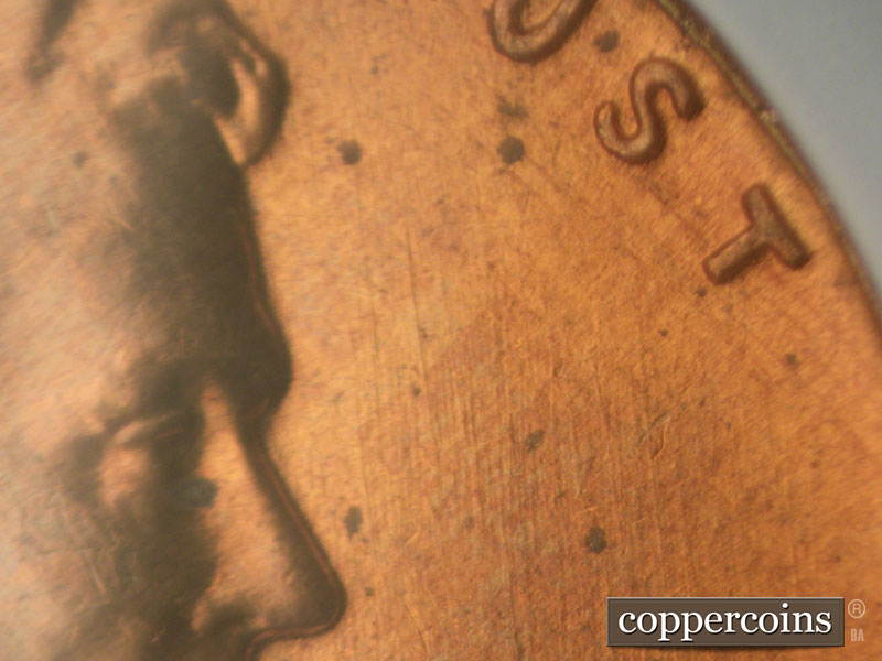 Die-stage B marker on 1960D•1MM•009 showing N/S die scratches in front of face.