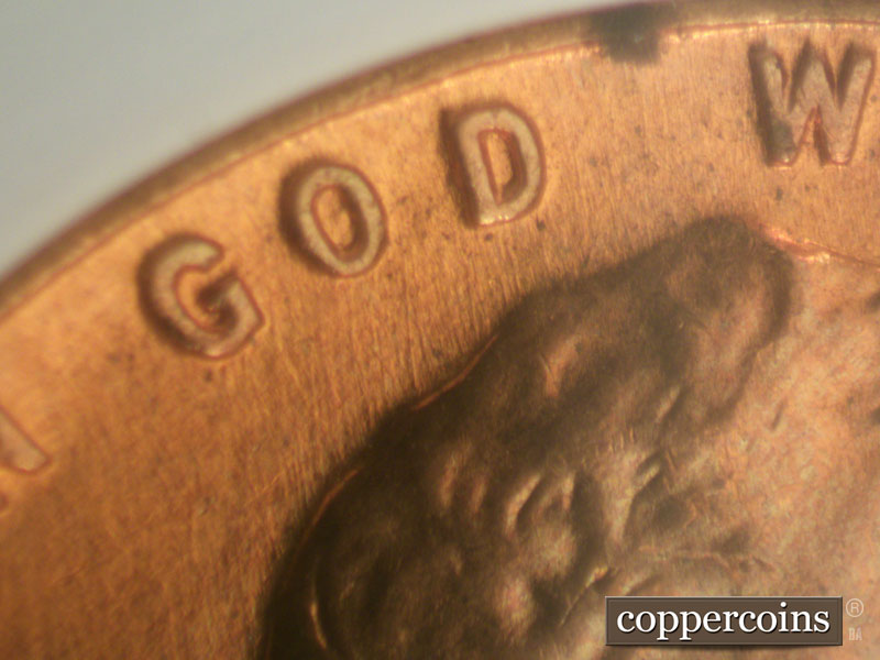 Die-stage B marker on 1960D•1MM•009 showing N/S die scratches from top of hair through GOD.