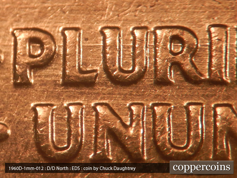 Die-stage A marker on 1960D•1MM•012 showing E/W die scratches through PLURIBUS.