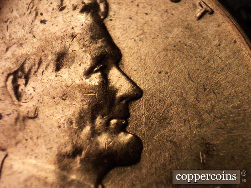 Die-stage B marker on 1960D•1MM•012 showing Die scratches in front of face.