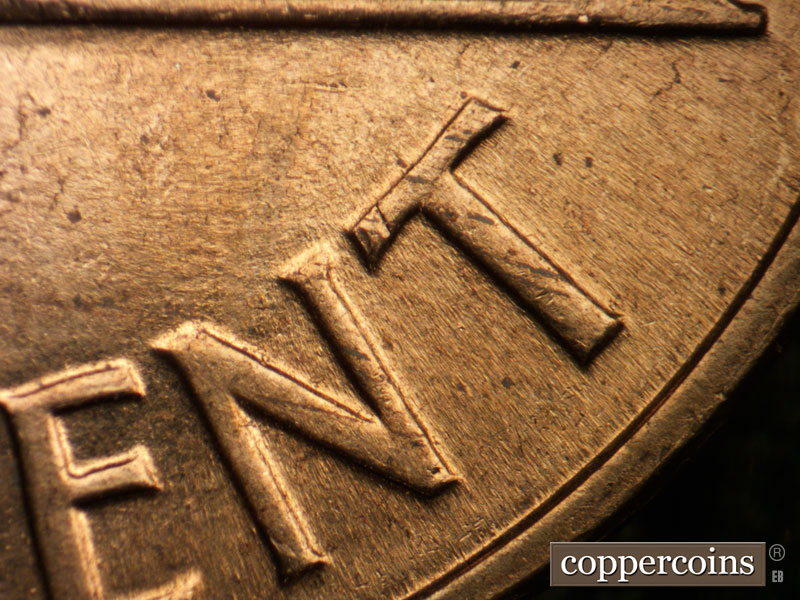 Die-stage B marker on 1960D•1MM•013 showing Multiple generally E/W die scratches above NT in CENT.