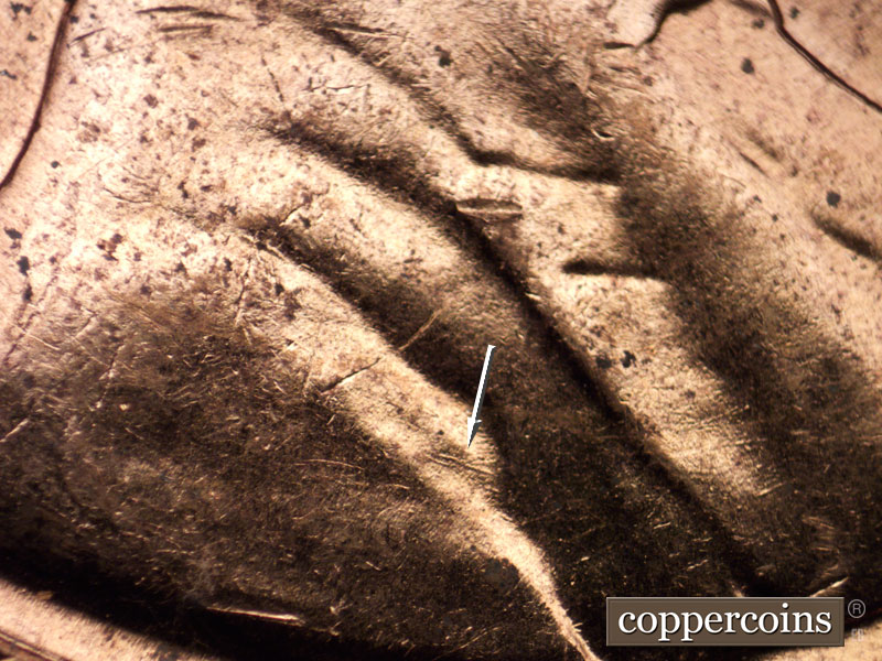 Die-stage C marker on 1960D•1MM•013 showing Die gouge in crease of shoulder.