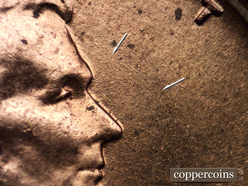 Die-stage C marker on 1960D•1MM•013 showing Light curved die scratch from front of forehead.