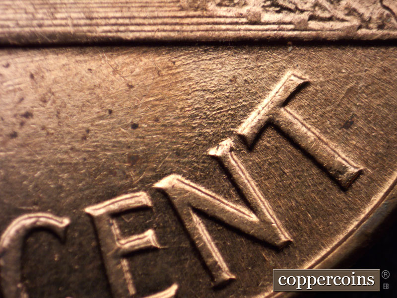 Die-stage C marker on 1960D•1MM•013 showing Multiple generally E/W die scratches above NT in CENT.