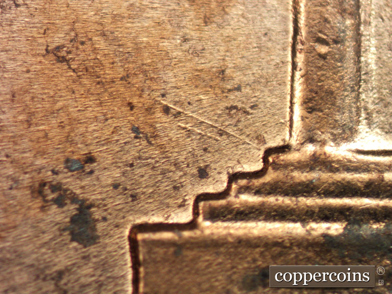 Die-stage A marker on 1960D•1MM•015 showing NW die scratch from left base.
