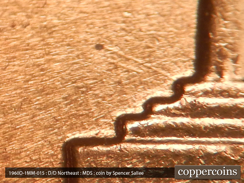 Die-stage B marker on 1960D•1MM•015 showing A die scratch runs NW from the base of the 1st column.