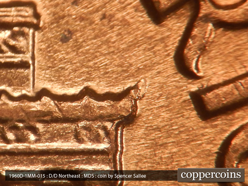 Die-stage B marker on 1960D•1MM•015 showing A die chip in the upper right cornice.