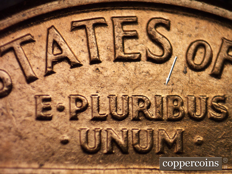 Die-stage A marker on 1960D•1MM•016 showing E/W die scratch above RIB in PLURIBUS.