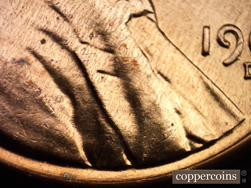 Die-stage A marker on 1960D•1MM•019 showing Concentric die scratches under the bust.