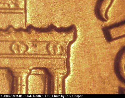 Die-stage C marker on 1960D•1MM•019 showing Die chips on lower right cornice edge.