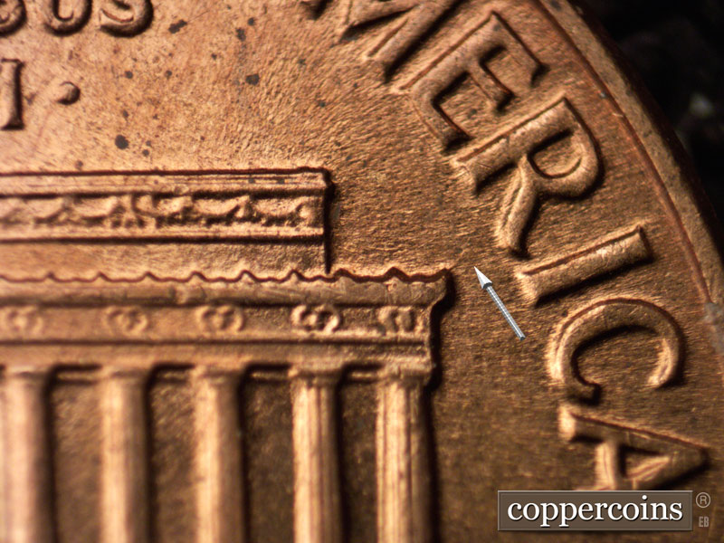 Die-stage C marker on 1960D•1MM•020 showing Die crack from tip of right cornice toward R in AMERICA.