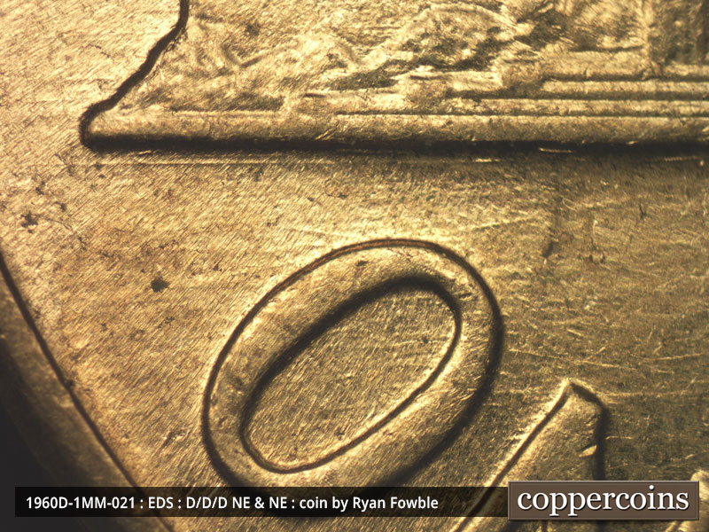 Die-stage A marker on 1960D•1MM•021 showing E/W die scratch under left base.