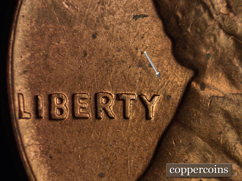 Die-stage B marker on 1960D•1MM•021 showing NE die scratch from tip of Y in LIBERTY.