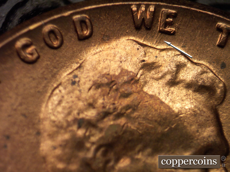 Die-stage B marker on 1960D•1MM•021 showing NNE die scratch from top of hair to E in WE.