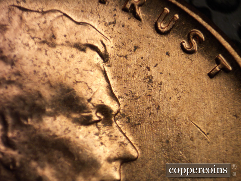Die-stage A marker on 1960D•1MM•022 showing Generally N/S die scratches in front of face.