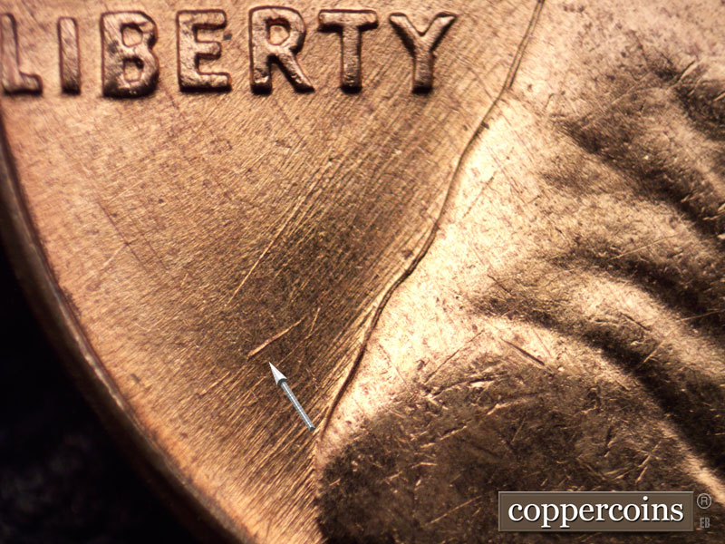 Die-stage A marker on 1960D•1MM•023 showing Heavy die gouge behind shoulder.