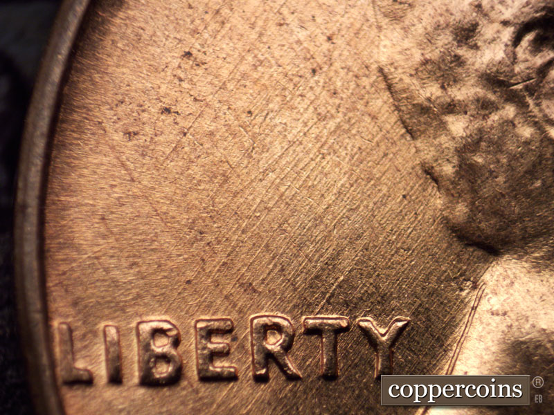 Die-stage A marker on 1960D•1MM•023 showing NE die scratches through LIBERTY.