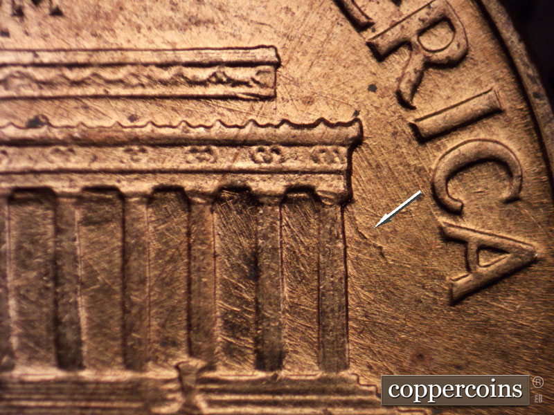Die-stage A marker on 1960D•1MM•023 showing Die break from bottom of right cornice.