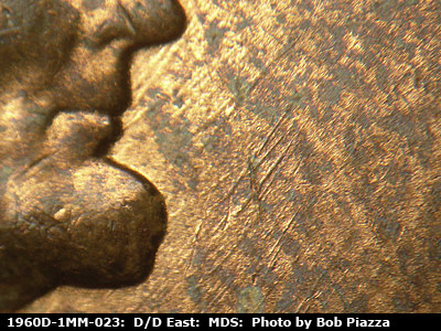 Die-stage B marker on 1960D•1MM•023 showing Numerous NE-SW die scratches in front of the face.